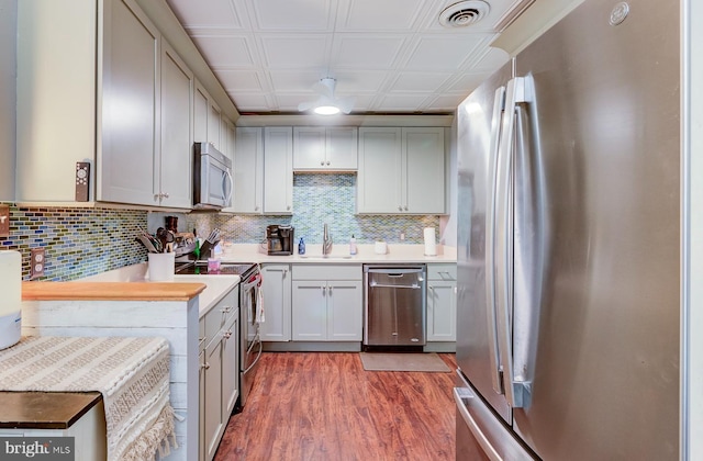 kitchen with visible vents, an ornate ceiling, stainless steel appliances, light countertops, and a sink