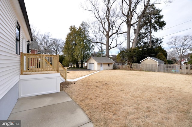 view of yard featuring an outbuilding, a detached garage, and fence