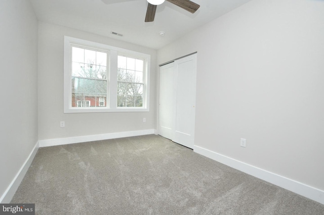 unfurnished bedroom with carpet, a closet, visible vents, a ceiling fan, and baseboards