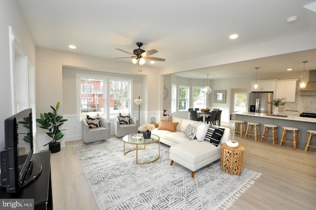 living room featuring a wainscoted wall, recessed lighting, a ceiling fan, and light wood-style floors