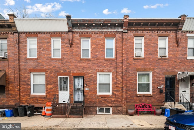 townhome / multi-family property with entry steps and brick siding