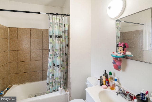 full bathroom with toilet, a sink, and shower / bath combo with shower curtain