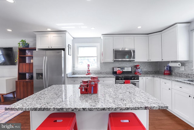 kitchen featuring stainless steel appliances, a kitchen bar, and a center island