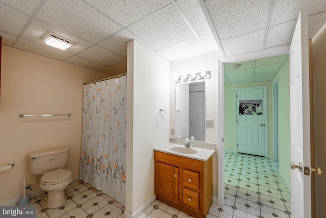 bathroom featuring curtained shower, a drop ceiling, vanity, and toilet