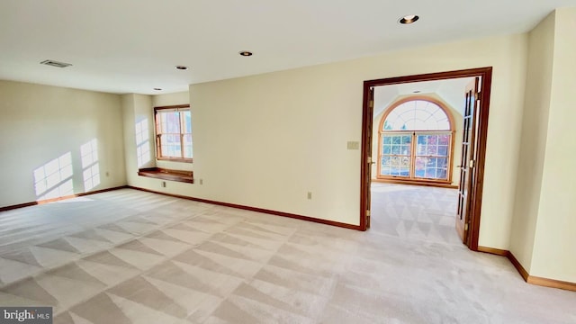 spare room featuring light colored carpet