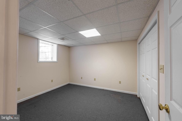 interior space with dark carpet and a drop ceiling