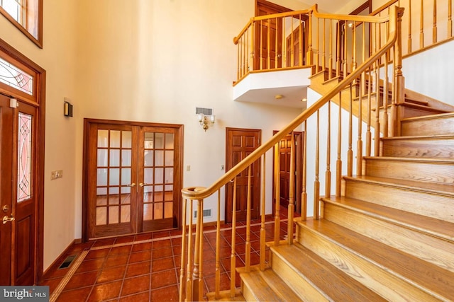 entrance foyer featuring a high ceiling, french doors, and tile patterned floors