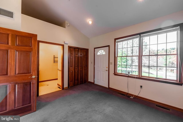 carpeted entryway featuring vaulted ceiling