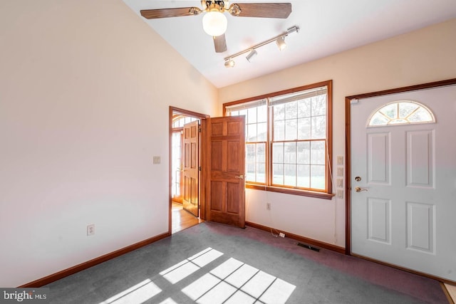 entryway with vaulted ceiling, ceiling fan, rail lighting, and light colored carpet