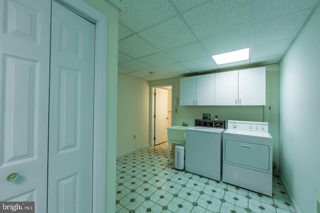 clothes washing area featuring washing machine and dryer and cabinets