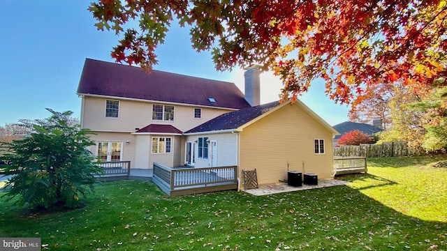 back of property with a deck and a yard