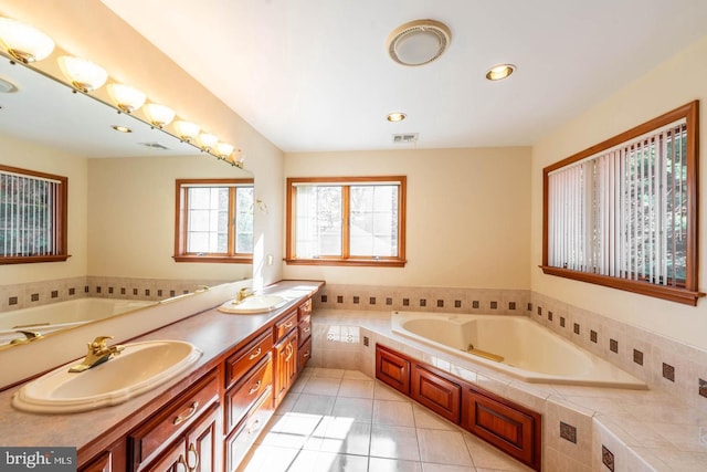 bathroom with tile patterned floors, vanity, and tiled tub