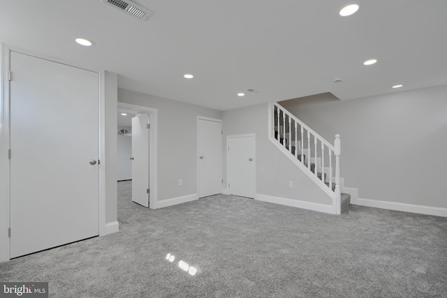 unfurnished room featuring recessed lighting, light colored carpet, visible vents, stairway, and baseboards