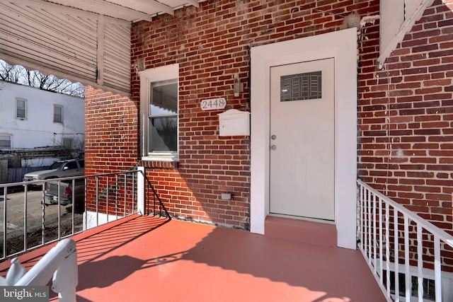 doorway to property featuring brick siding