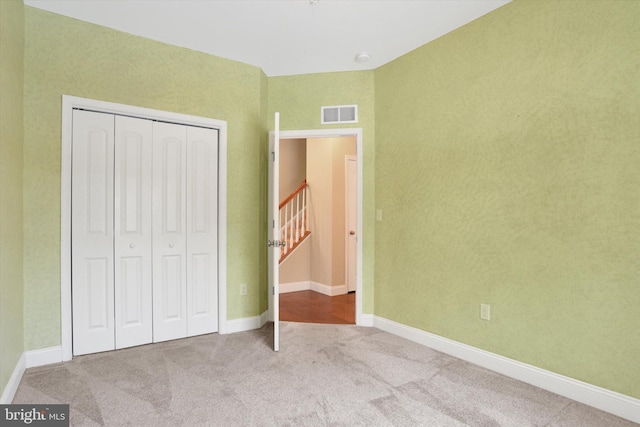 unfurnished bedroom with carpet floors and a closet