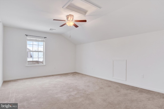 carpeted spare room featuring vaulted ceiling and ceiling fan