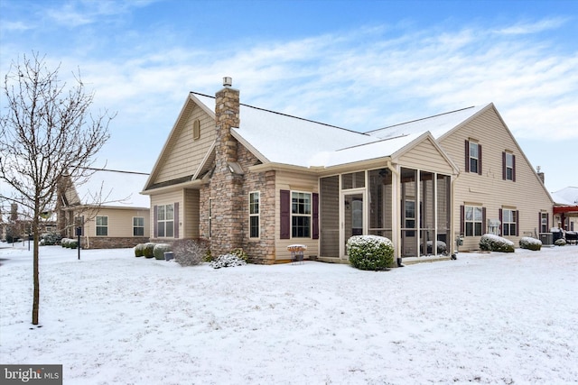 snow covered house with a sunroom