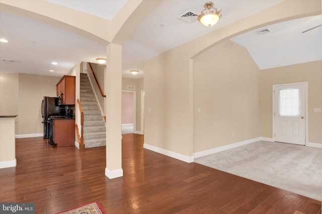 foyer entrance with dark hardwood / wood-style flooring and lofted ceiling