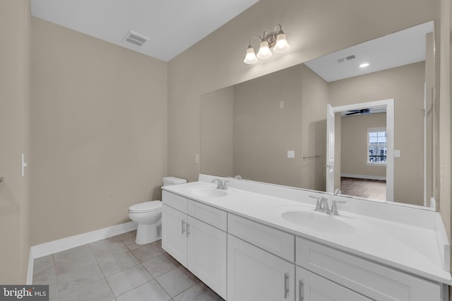 bathroom with tile patterned flooring, vanity, toilet, and ceiling fan