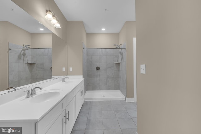 bathroom featuring tile patterned flooring, vanity, and a tile shower