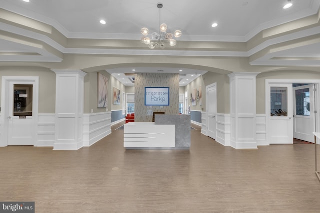 reception area with decorative columns and an inviting chandelier