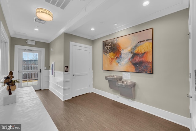 foyer with dark wood-type flooring and ornamental molding