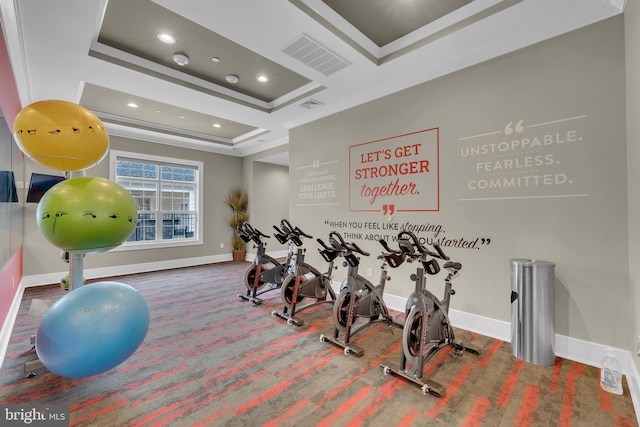 exercise area featuring crown molding and a raised ceiling