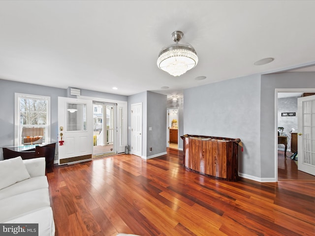 living room with dark hardwood / wood-style flooring and a chandelier