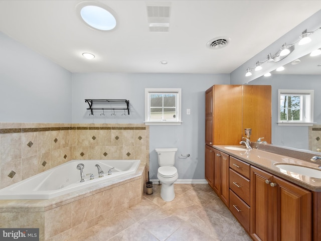 bathroom with vanity, tile patterned floors, tiled bath, and toilet