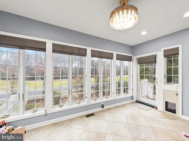 unfurnished sunroom featuring a notable chandelier