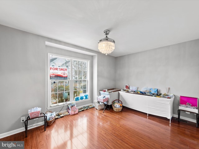 recreation room with an inviting chandelier and hardwood / wood-style floors