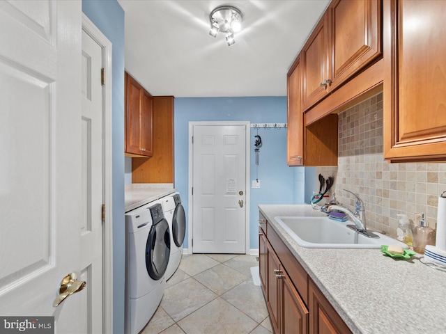 laundry area featuring sink, cabinets, washing machine and clothes dryer, and light tile patterned flooring