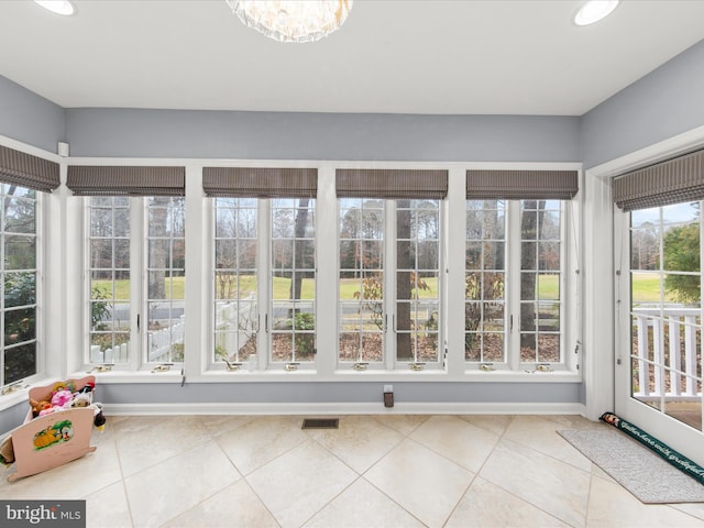 unfurnished sunroom with a notable chandelier