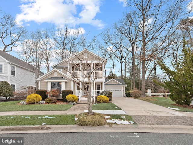 view of front facade featuring a garage, a balcony, a front yard, and covered porch