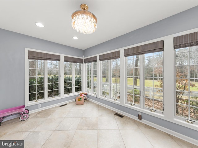 unfurnished sunroom with a healthy amount of sunlight and a notable chandelier