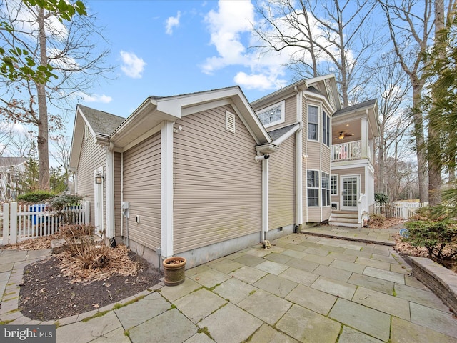 view of home's exterior with a balcony, ceiling fan, and a patio area