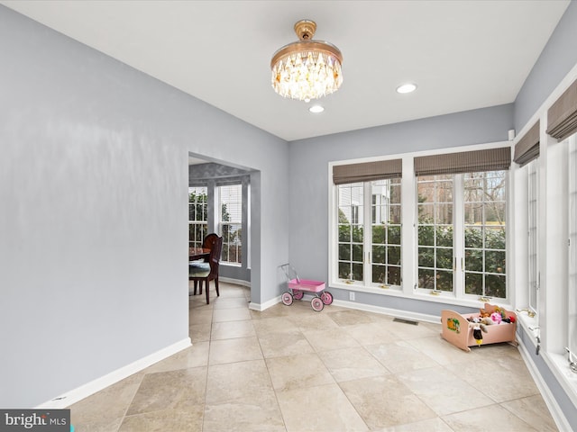 interior space with light tile patterned flooring and a notable chandelier