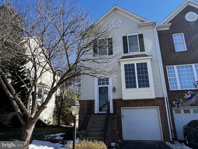 view of front facade with brick siding and an attached garage