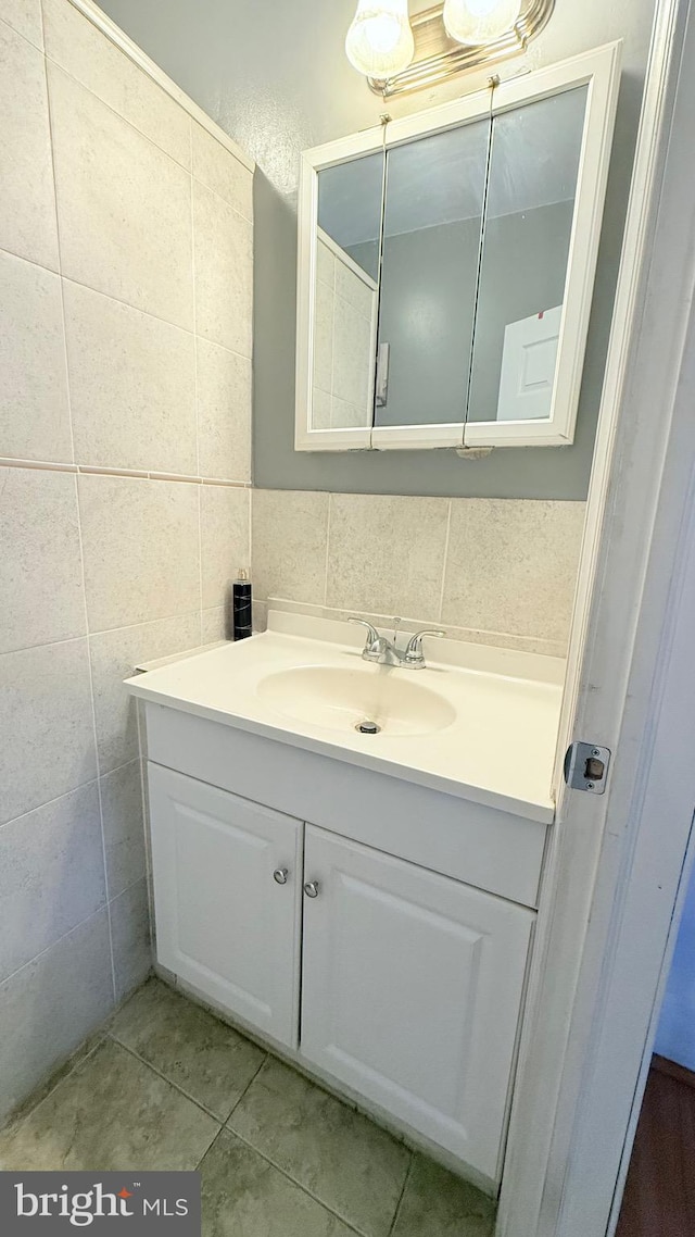 bathroom with tile patterned flooring, tile walls, and vanity