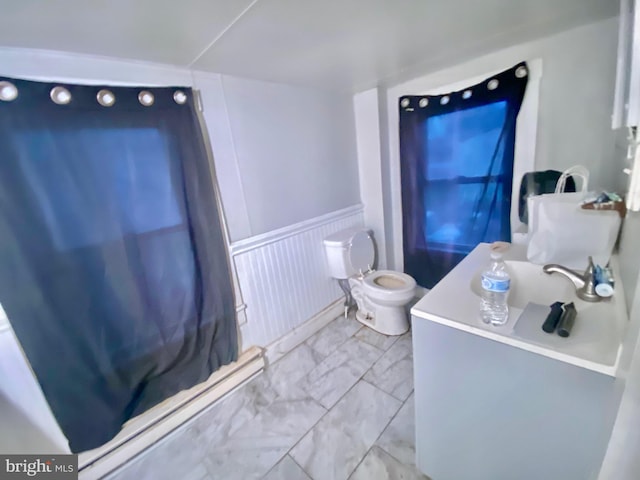 bathroom with toilet, a wainscoted wall, marble finish floor, and vanity