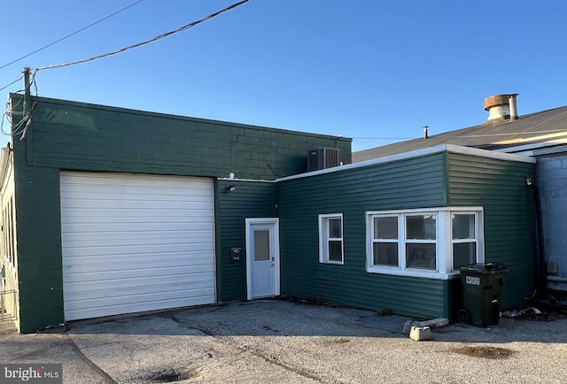 view of front of property with central AC, driveway, and a garage