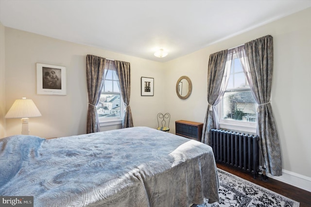 bedroom featuring radiator and dark hardwood / wood-style flooring