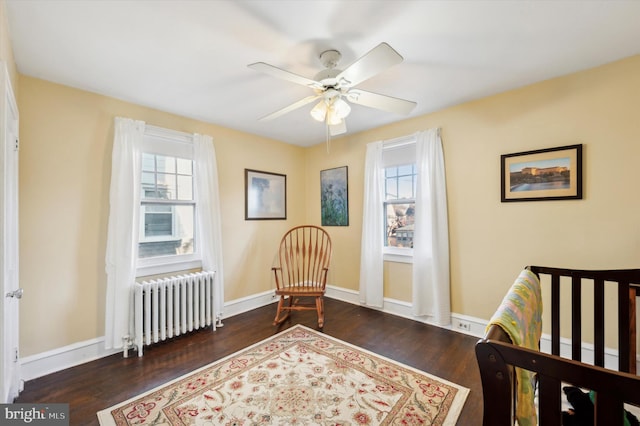 bedroom featuring ceiling fan, dark wood-type flooring, and radiator heating unit