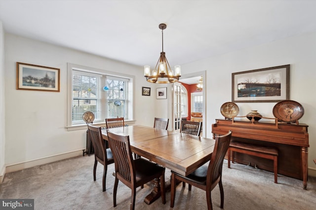 dining space featuring light colored carpet and a notable chandelier