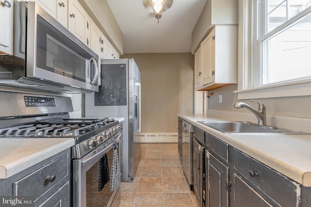 kitchen with a sink, light countertops, white cabinetry, and stainless steel appliances