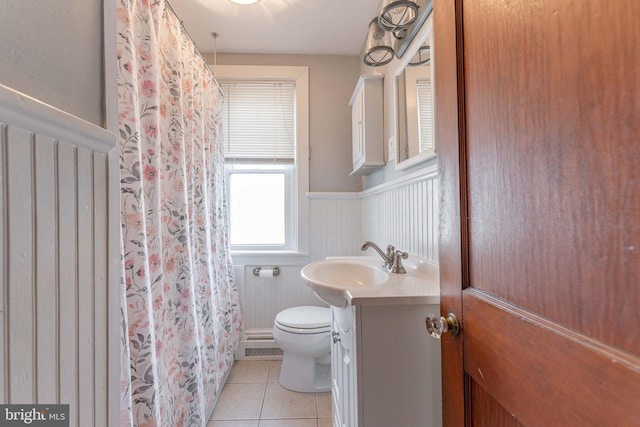 full bathroom featuring vanity, wainscoting, tile patterned floors, toilet, and baseboard heating