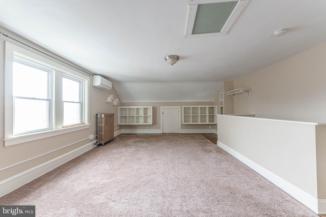 unfurnished living room with an AC wall unit, carpet floors, radiator, baseboards, and vaulted ceiling