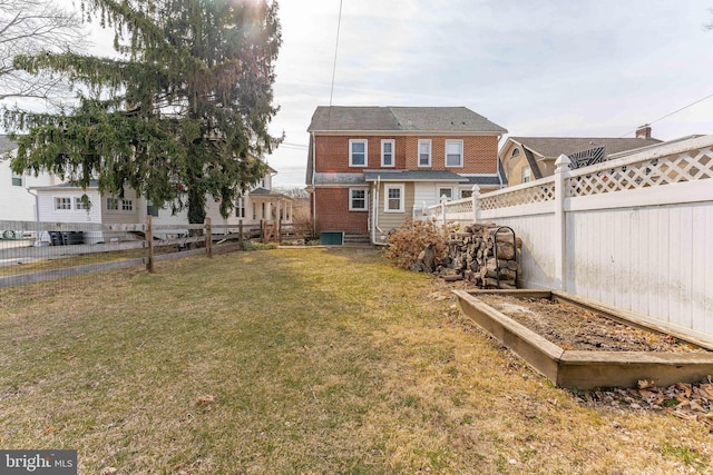 view of yard featuring entry steps, a vegetable garden, and a fenced backyard