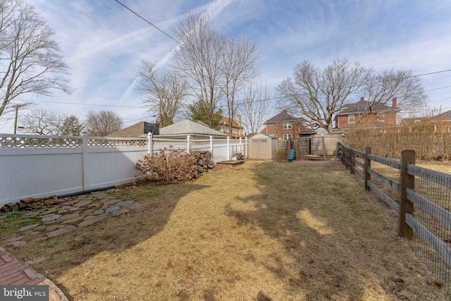 view of yard with a storage unit, a fenced backyard, and an outdoor structure