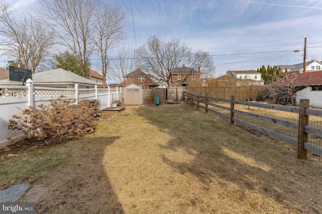 view of yard featuring a storage unit, an outbuilding, and a fenced backyard